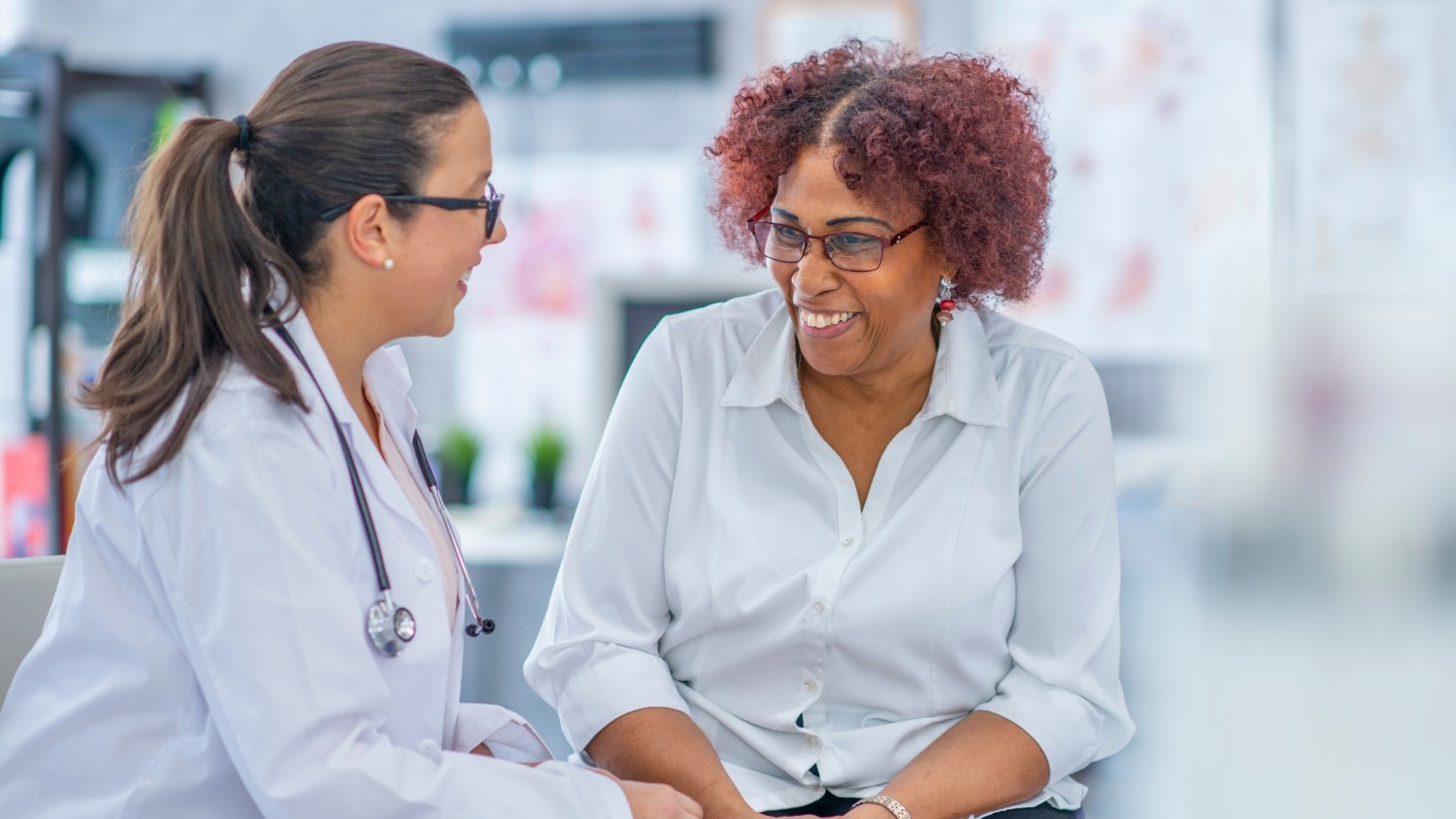 A patient smiles while speaking with her concierge doctor.